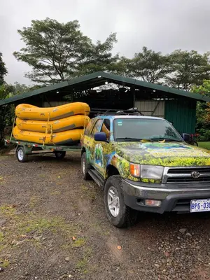 a truck parked next to a trailer with a surfboard at Epic Adventure Lodge in San Miguel