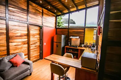 a room with a kitchen with a table and a couch at Casa Higueron in Monteverde Costa Rica