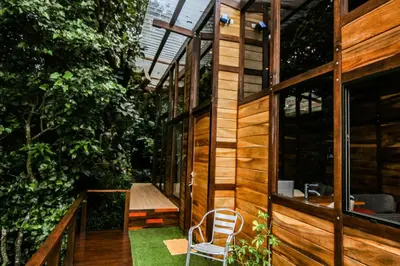 a wooden house with a chair on a porch at Casa Higueron in Monteverde Costa Rica