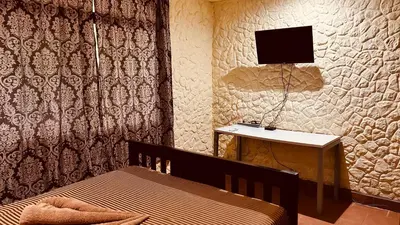 a bedroom with a bed and a tv on a wall at Casa Encantada offers you Two-Bedroom House, 1 Tiny Apartment & 3 Double Rooms in Manuel Antonio