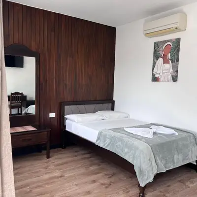 a bedroom with a large bed and a mirror at Hotel Naralit in Tilarán