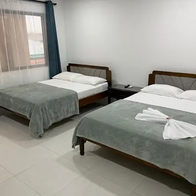 two beds sitting next to each other in a room at Hotel Naralit in Tilarán