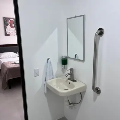 a white bathroom with a sink and a mirror at Hotel Naralit in Tilarán
