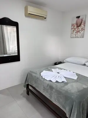 a bedroom with a bed with a white flower on it at Hotel Naralit in Tilarán