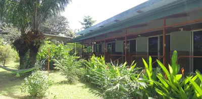 a house with a hammock in front of it at Karandi Hostel in Uvita