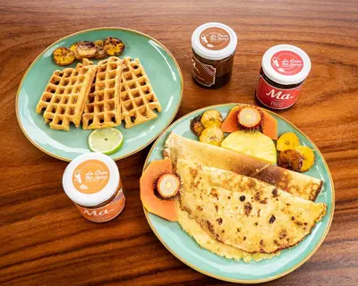 a table with two plates of food with waffles and syrup at Lodge Las Estrellas de Samara - Ocean View in Sámara