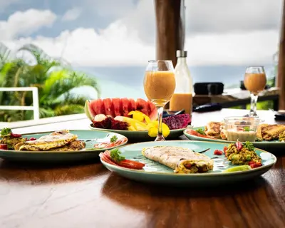 a table with plates of food and glasses of wine at Lodge Las Estrellas de Samara - Ocean View in Sámara