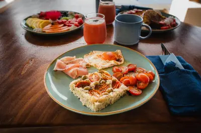 a table with plates of food on a wooden table at Lodge Las Estrellas de Samara - Ocean View in Sámara