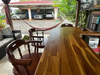 a wooden table with chairs and a hammock around it at LOFTSCACAO APARTMENTS, Villas Cacao, near to Playa Bonita Limón in Puerto Limón