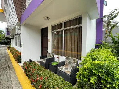 a house with two chairs and flowers in front of it at LOFTSCACAO APARTMENTS, Villas Cacao, near to Playa Bonita Limón in Puerto Limón