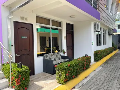 a building with a door and a couch on a sidewalk at LOFTSCACAO APARTMENTS, Villas Cacao, near to Playa Bonita Limón in Puerto Limón