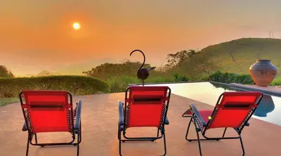 two chairs and a bird sitting on a table next to a pool at Magic Mountain Views Villa in Atenas