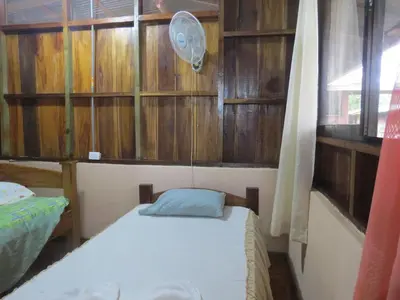 a small room with a bed and a fan at Poponjoche Lodge Caño Negro in Caño Negro