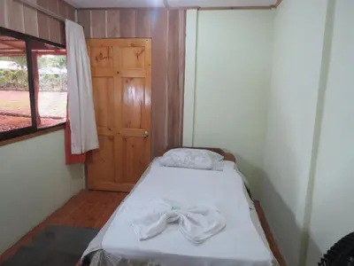 a small room with a bed with a bow on it at Poponjoche Lodge Caño Negro in Caño Negro