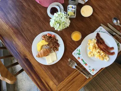 two plates of breakfast food on a wooden table at Poas Volcano Lodge in Vara Blanca