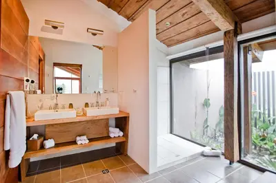 a bathroom with two sinks and a large window at Poas Volcano Lodge in Vara Blanca