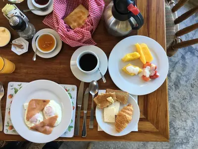 a table with two plates of food and a cup of coffee at Poas Volcano Lodge in Vara Blanca