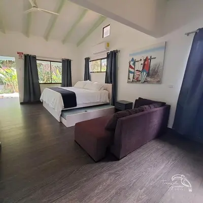 a bedroom with a bed and a couch at Tropical Garden Hotel in Jacó