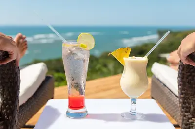 two cocktails on a table with a view of the ocean at El Castillo Luxury Boutique Hotel- in Ojochal