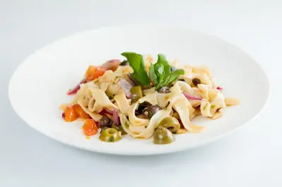 a plate of pasta salad with peas and olives at El Castillo Luxury Boutique Hotel- in Ojochal
