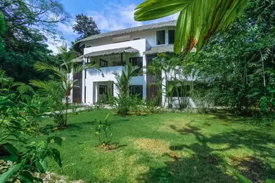 an exterior view of a house with a yard at Makara Suite Mariposa Ground Floor in Uvita