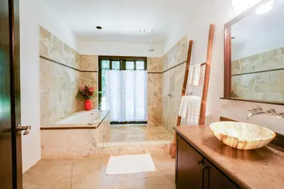 a large bathroom with a tub and a sink and a tub at Makara Suite Mariposa Ground Floor in Uvita