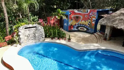 a swimming pool in a resort with a painting on the wall at Massai Apartments in Playa Flamingo