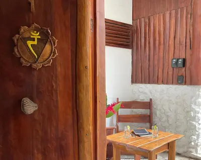 a wooden table in a room with a wooden door at Hotel Entre Dos Aguas in Sámara