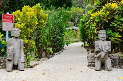 two stone statues sitting next to a path at Hotel Entre Dos Aguas in Sámara