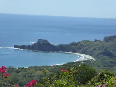 a view of a beach with a rock in the ocean at Hotel Entre Dos Aguas in Sámara