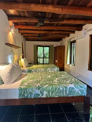 a bedroom with two beds and a window at Hotel Entre Dos Aguas in Sámara