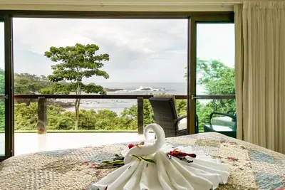 a swan on a bed in front of a window at Cocobolo Beach Boutique Hotel in San Juanillo