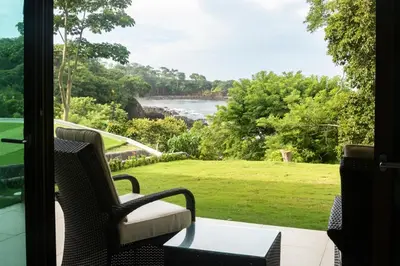 a porch with a chair and a table and a view of the water at Cocobolo Beach Boutique Hotel in San Juanillo