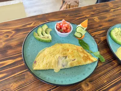 a blue plate with a tortilla and a salad and fruit at Cocobolo Beach Boutique Hotel in San Juanillo