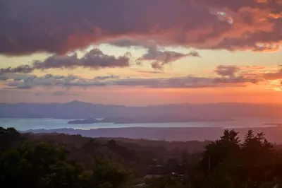 a sunset with a view of the ocean and mountains at Senda Monteverde Hotel Member of the Cayuga Collection in Monteverde Costa Rica