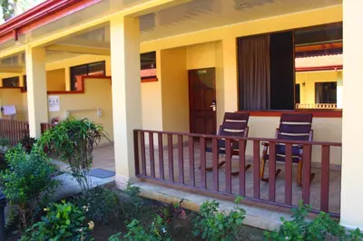 two chairs sitting on the front porch of a house at La Foresta Nature Resort in Quepos