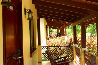 a porch with a chair and awning on a house at La Foresta Nature Resort in Quepos