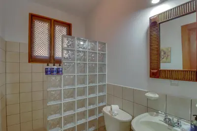 a bathroom with a sink and a toilet and a mirror at Bahia Azul 7A in Jacó