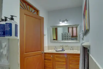 a bathroom with a sink and a mirror at Bahia Azul 7A in Jacó