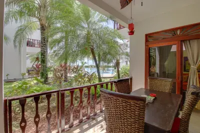 a balcony with a table and chairs and palm trees at Bahia Azul 7A in Jacó