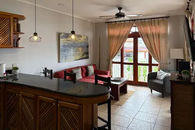 a kitchen and living room with a couch and a table at La Paloma Blanca B3 in Jacó