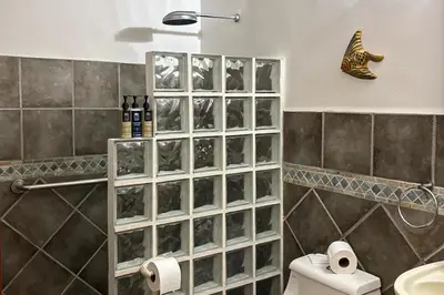 a bathroom with a shower and a toilet and towels at La Paloma Blanca B3 in Jacó