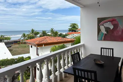 a balcony with a table and a view of the ocean at La Paloma Blanca B3 in Jacó