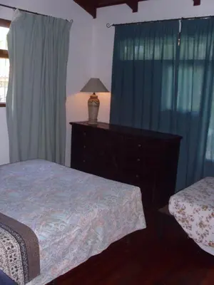 a bedroom with two beds and a dresser with a lamp at Condominio Villa Hermosa in Playa Hermosa