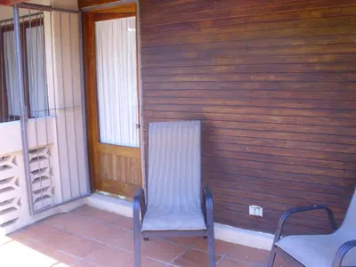 a room with two chairs and a wooden wall at Condominio Villa Hermosa in Playa Hermosa