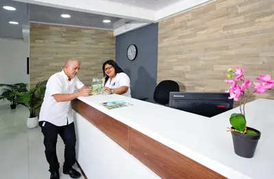 a man and a woman standing at a reception desk at Hotel Milan Costa Rica in San José