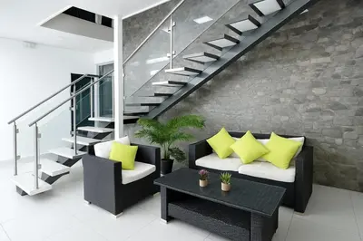 a living room with yellow pillows and a staircase at Hotel Milan Costa Rica in San José