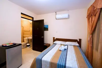 a bedroom with a bed with a teddy bear on it at Hotel El Cerro in Liberia