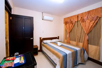 a bedroom with a bed and a black door at Hotel El Cerro in Liberia