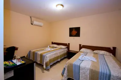 a hotel room with two beds with towels on them at Hotel El Cerro in Liberia